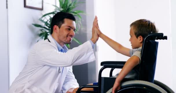 Doctor giving high five to disable boy — Stock Video