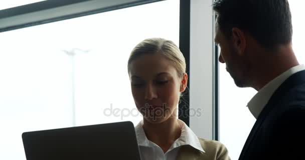 Empresario y mujer discutiendo en el ordenador portátil — Vídeos de Stock