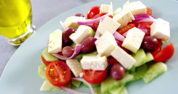 Греческий салат на тарелке и на столе — стоковое видео