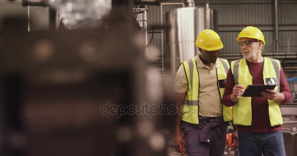 Trabajadores discutiendo sobre portapapeles — Vídeo de stock