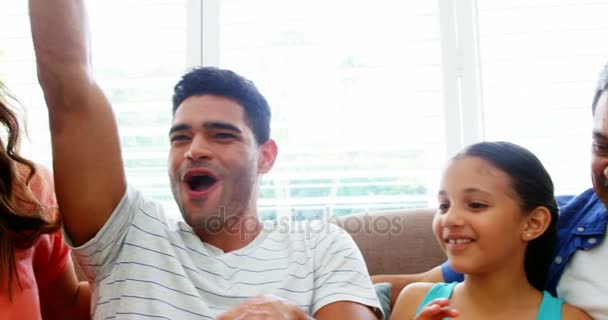 Семья смотрит телевизор и веселится — стоковое видео