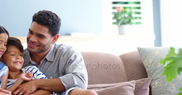 Familia sentada en el sofá y abrazándose en la sala de estar — Vídeos de Stock