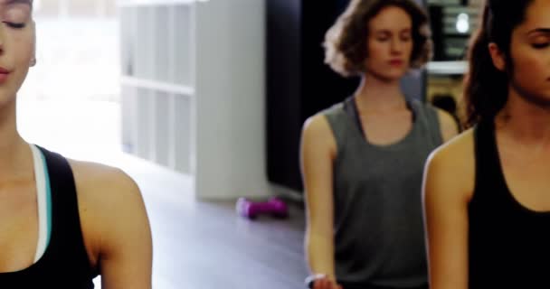 Mujeres practicando yoga en gimnasio — Vídeos de Stock