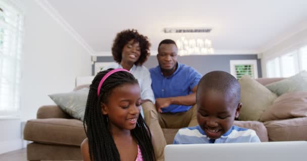 Çocuklar oturma odasında dizüstü bilgisayar kullanarak — Stok video
