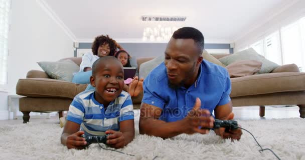 Vader en zoon afspelen van video game in woonkamer — Stockvideo