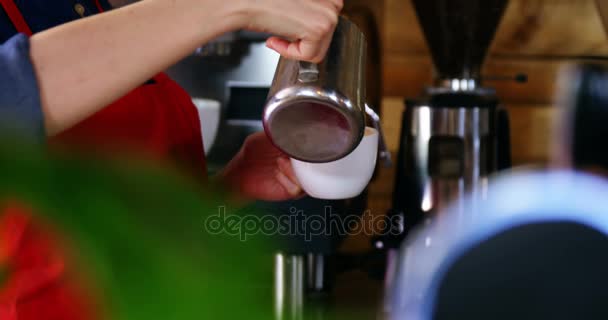 Σερβιτόρα χύνοντας γάλα στον καφέ στο γκισέ — Αρχείο Βίντεο
