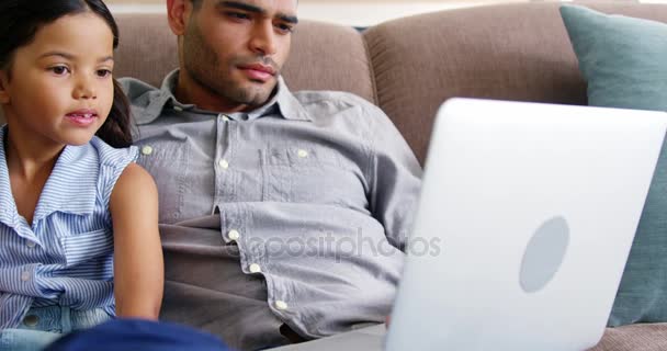 Padre e hija usando portátil en la sala de estar — Vídeos de Stock