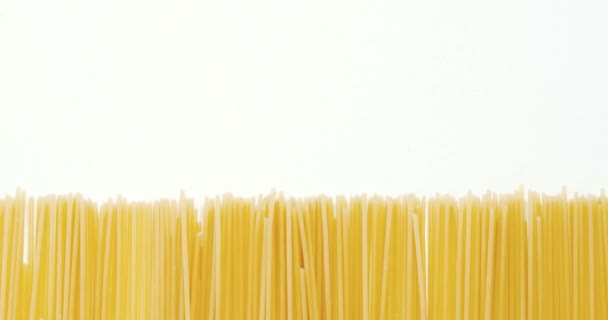 Raw spaghetti arranged on white background — Stock Video