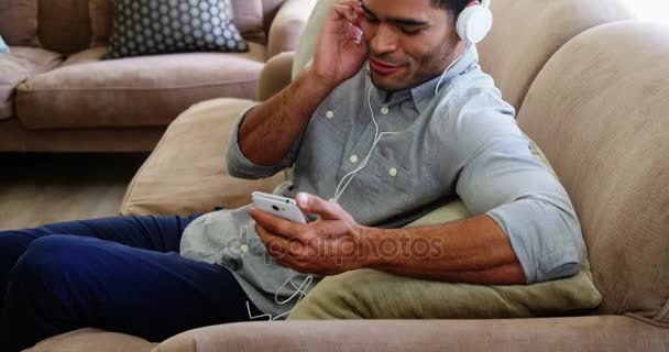 Человек слушает музыку на мобильном телефоне — стоковое видео