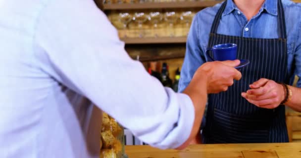 Waiter serving coffee to male costumer at counter — Stock Video