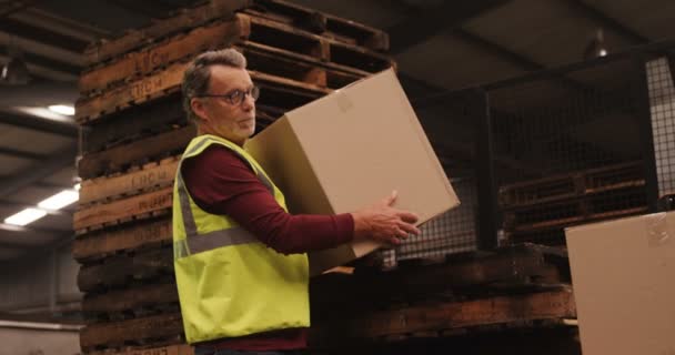 Рабочий упорядочивает коробку на складе — стоковое видео