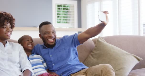 Keluarga duduk di sofa dan mengambil selfie — Stok Video