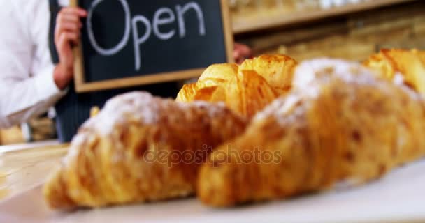 Smiling waiter holding open sign board — Stock Video