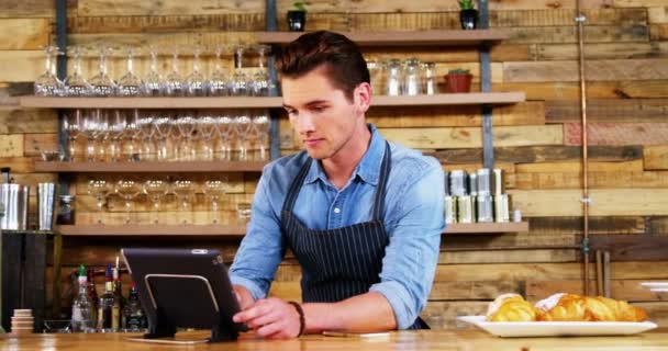 Mannelijke ober met behulp van digitale tablet aan balie — Stockvideo