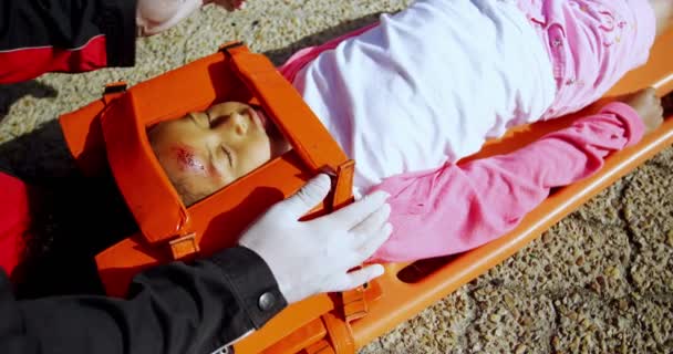 Paramedicus helpt gewonde meisje — Stockvideo
