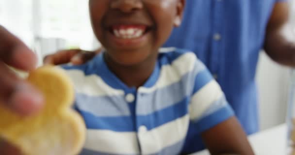 Хлопчик їсть печиво у формі серця — стокове відео
