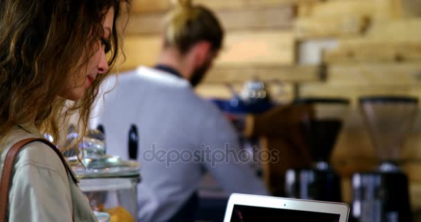 Mujer usando el ordenador portátil mientras toma café — Vídeos de Stock