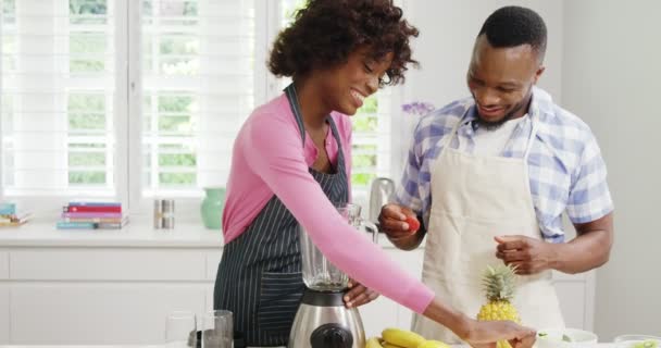 Happy man and woman preparing juice in juicer — Stock Video