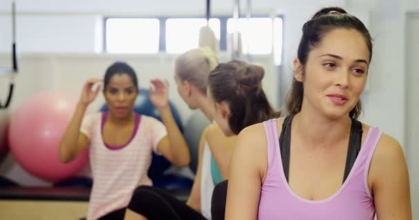 Hermosa mujer interactuando entre sí en el gimnasio — Vídeo de stock