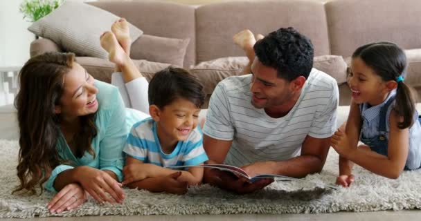 Gelukkige familie leesboek in woonkamer — Stockvideo