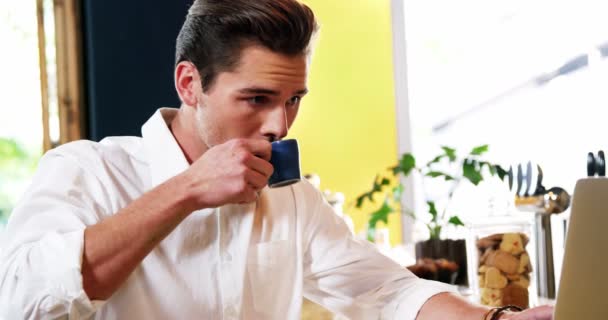 Чоловічий клієнт використовує ноутбук, маючи каву — стокове відео