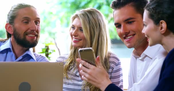 Gelukkige vrienden met behulp van de laptop en mobiele telefoon — Stockvideo