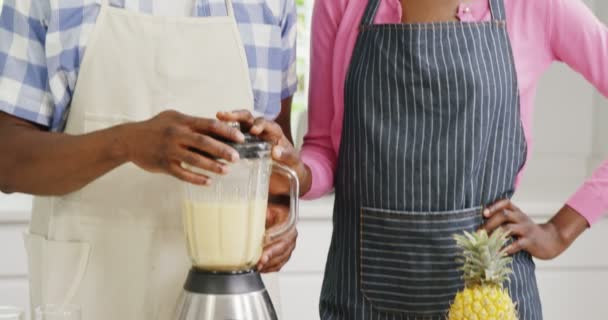 Feliz hombre y mujer preparando jugo en exprimidor — Vídeos de Stock