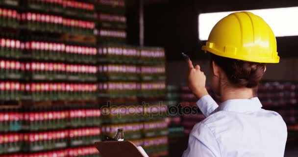 Female supervisor maintaining record on clipboard — Stock Video