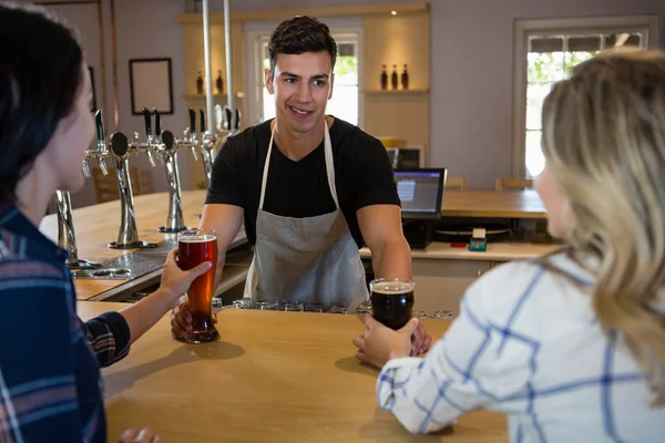 Barman que serve bebidas para jovens amigos — Fotografia de Stock