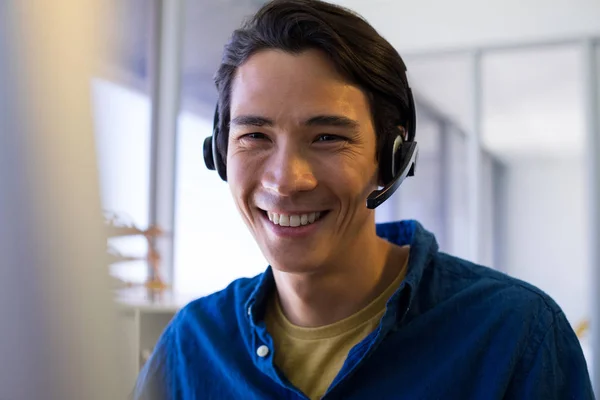 Hombre ejecutivo en auriculares en su escritorio — Foto de Stock