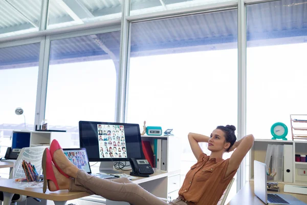 Female executive relaxing at her desk — Stock Photo, Image