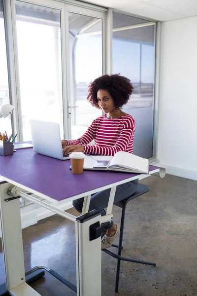 Kvinnliga verkställande arbetar över laptop — Stockfoto