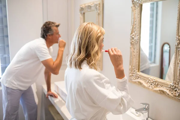 Пара чистячих зубів перед дзеркалом — стокове фото