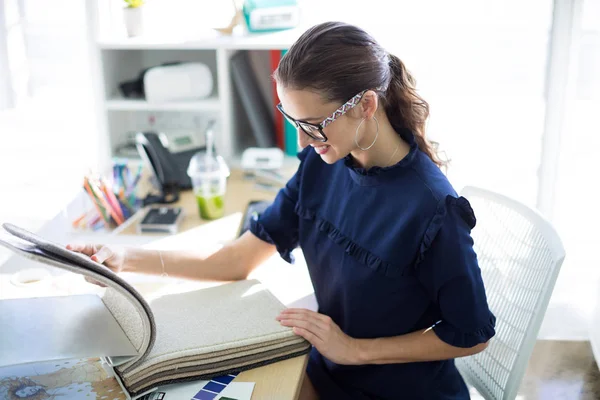 Executivo feminino olhando para livro de amostra — Fotografia de Stock