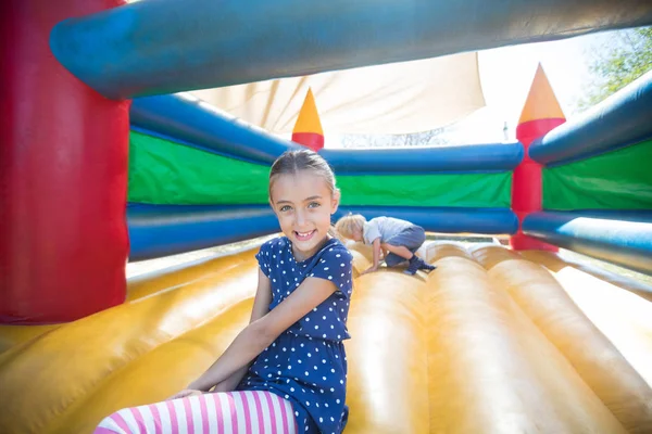 Chica feliz sentado en castillo hinchable — Foto de Stock