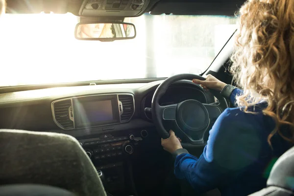 Woman test driving at showroom — Stock Photo, Image