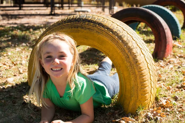 Menina feliz brincando com pneu — Fotografia de Stock