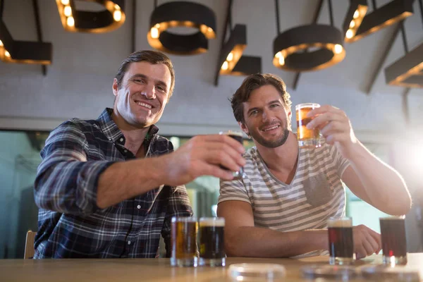 Amigos felizes segurando copo de cerveja — Fotografia de Stock