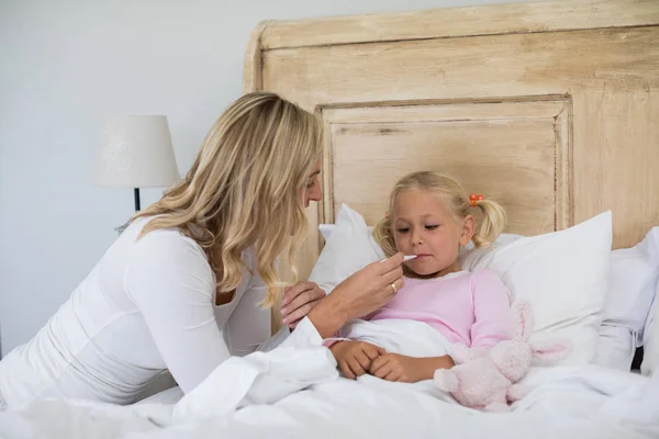 Мати перевіряє температуру хворої дочки — стокове фото