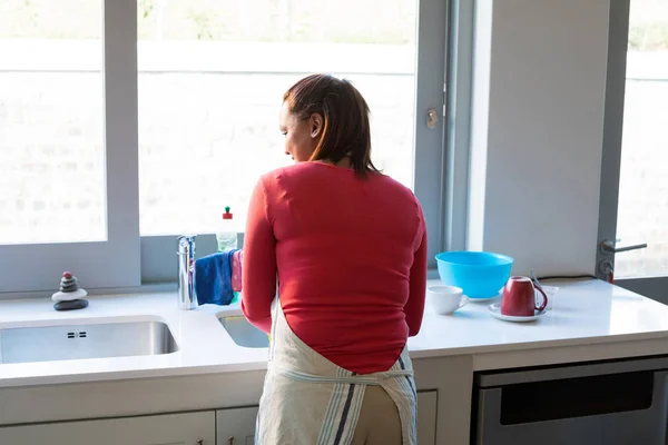 Mujer lavando utensilio en fregadero de cocina —  Fotos de Stock