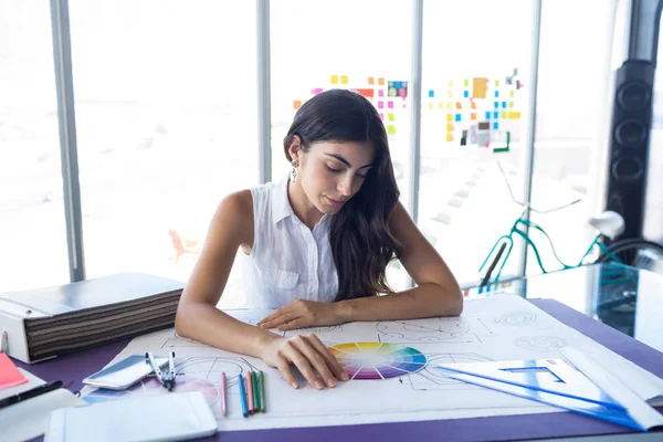 Arquitecta mujer trabajando en el plano en el escritorio — Foto de Stock