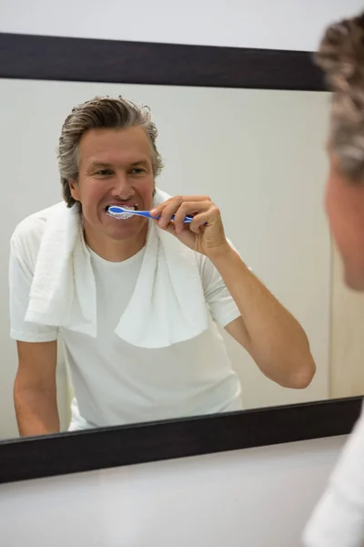 Mann putzt sich im Badezimmer die Zähne — Stockfoto