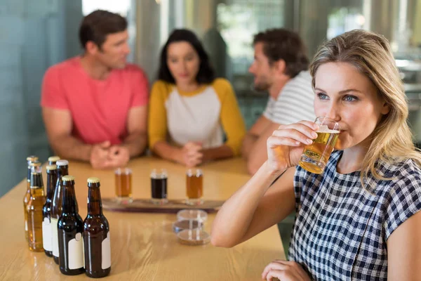 Vrouw met biertje terwijl vrienden — Stockfoto