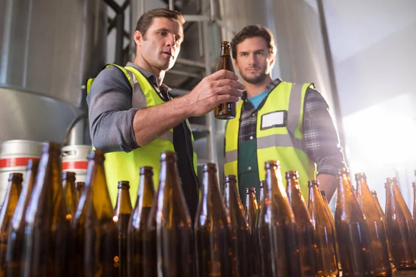 Compañeros examinando botellas de cerveza — Foto de Stock