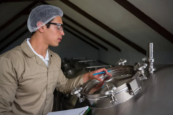 Travailleur examinant le réservoir de stockage — Photo