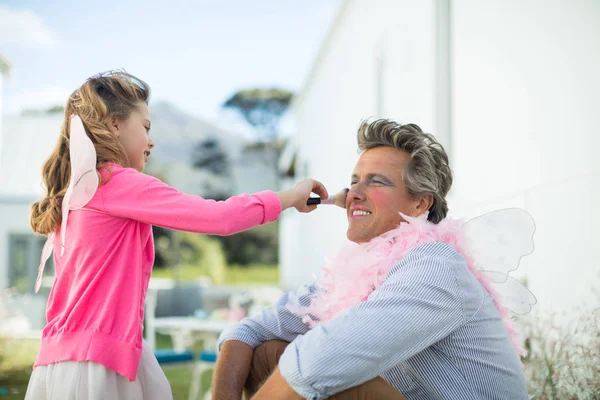 Dcera v pohádkové kostýmy dát make-up na obličej otcové — Stock fotografie