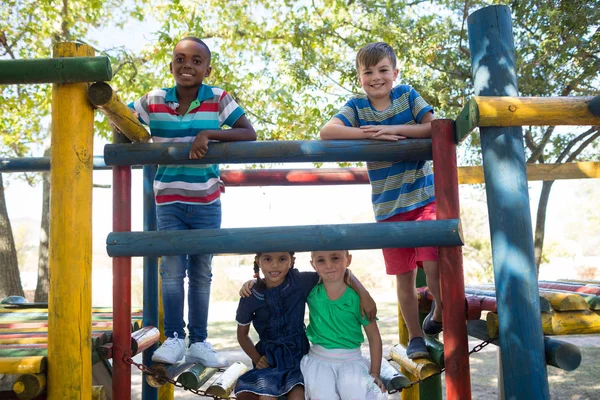 Друзі, насолоджуючись в спортзалі джунглів на дитячому майданчику — стокове фото
