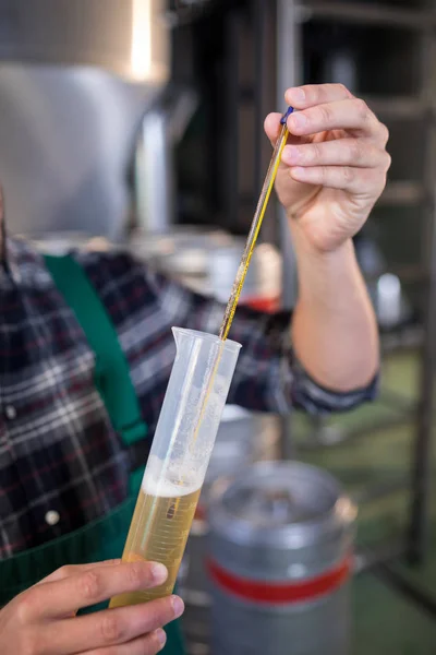 Cropped hand of worker testing beer — Stock Photo, Image