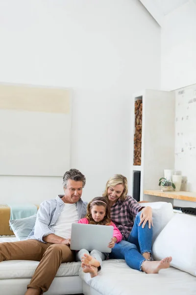 Família usando laptop juntos na sala de estar — Fotografia de Stock