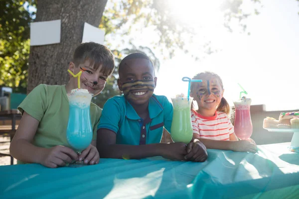 Děti s barvou tváře popíjejí u parku — Stock fotografie